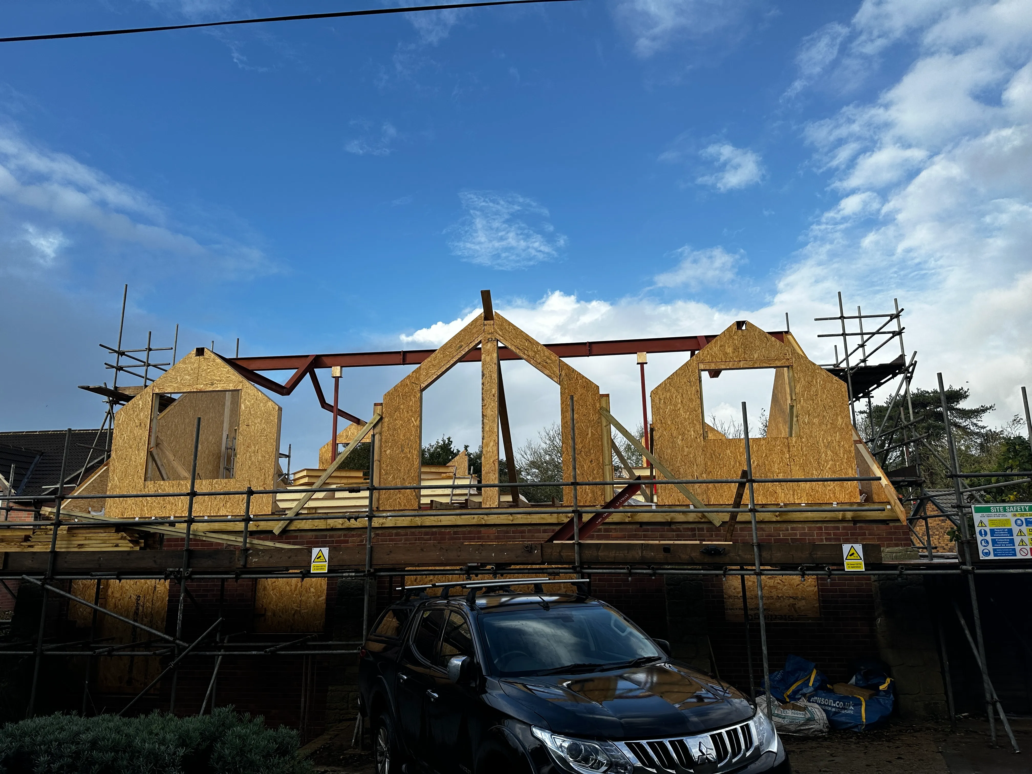 a car is parked in front of a house under construction