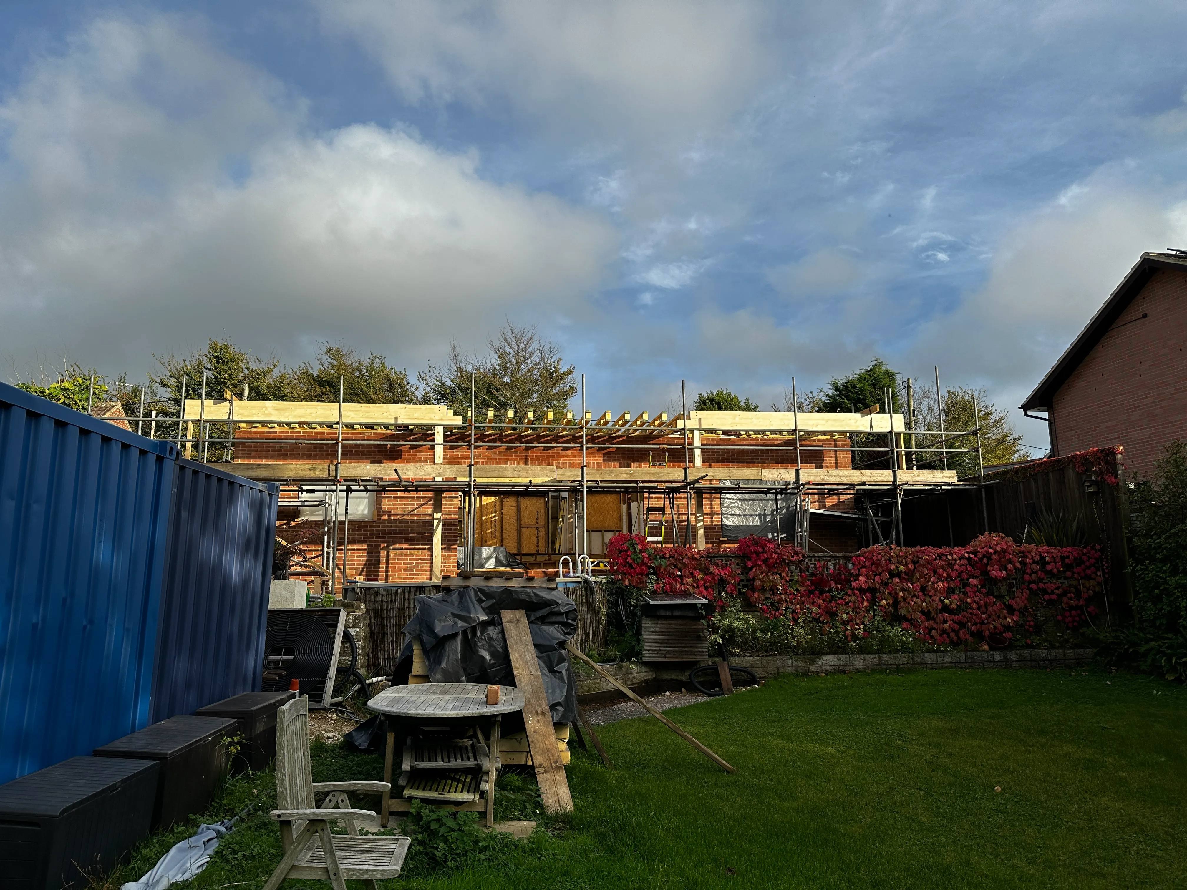 a house under construction with a blue container in the foreground